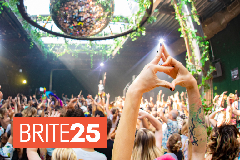 A crowd hold their hands aloft at a Daybreaker event.